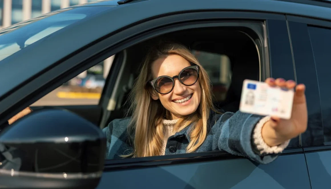 Woman smiling holding driving license